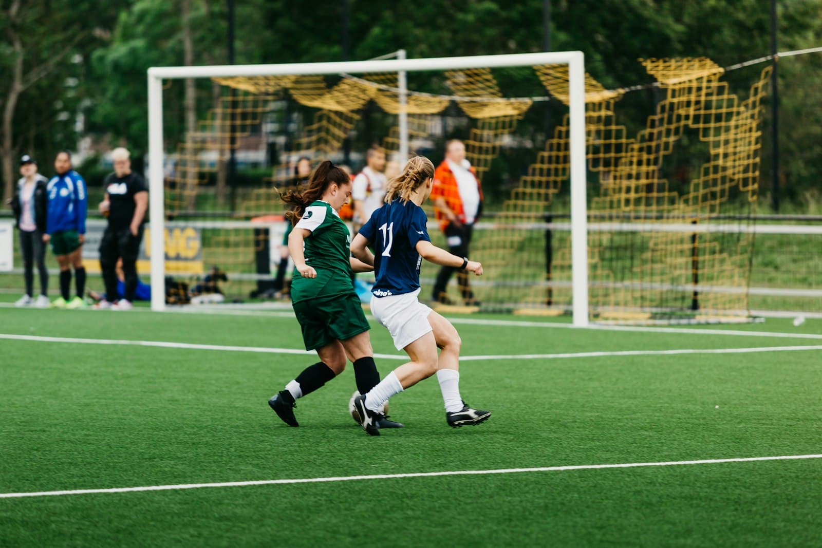 A late tackle in front of the goal at a grassroots night match